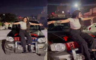 woman-shows-middle-finger-while-sitting-on-govt-vehicle-bonnet-for-instagram-reel-viral-clip-leads-to-police-officer-suspension-watch